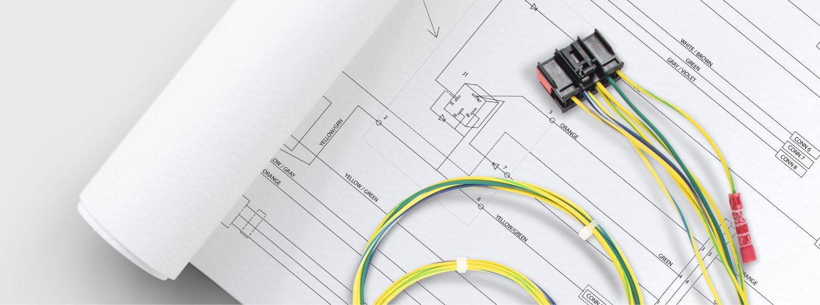 An image of a wire diagram page in a booklet with the Ford wiring harness by Muncie Power Products laying on top of the page.