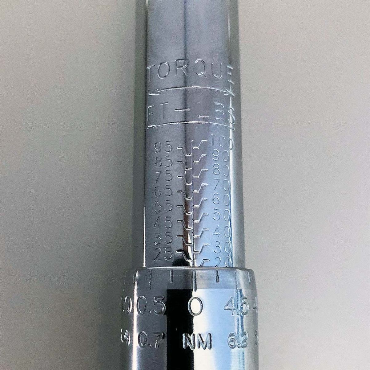 An image of a torque wrench showing adjustment range of 20–100 ft. lbs.