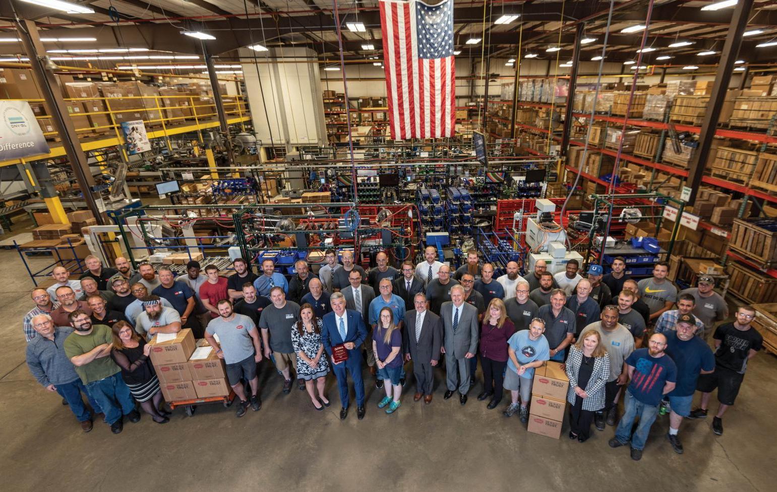 Muncie Power Products employees gather as they present the NTEA 55-year membership plaque.