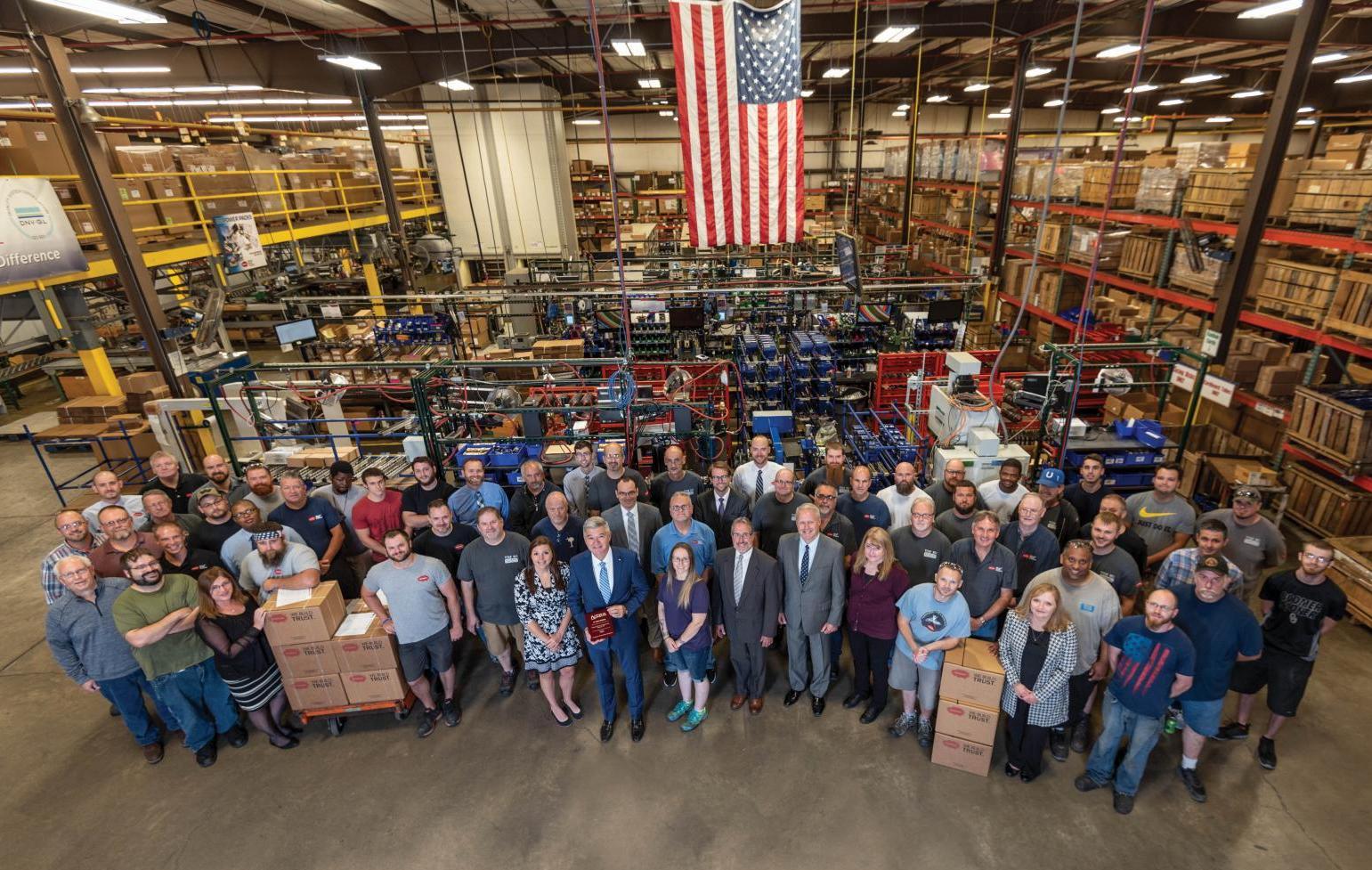 Muncie Power Products employees gather as they present the NTEA 55-year membership plaque.