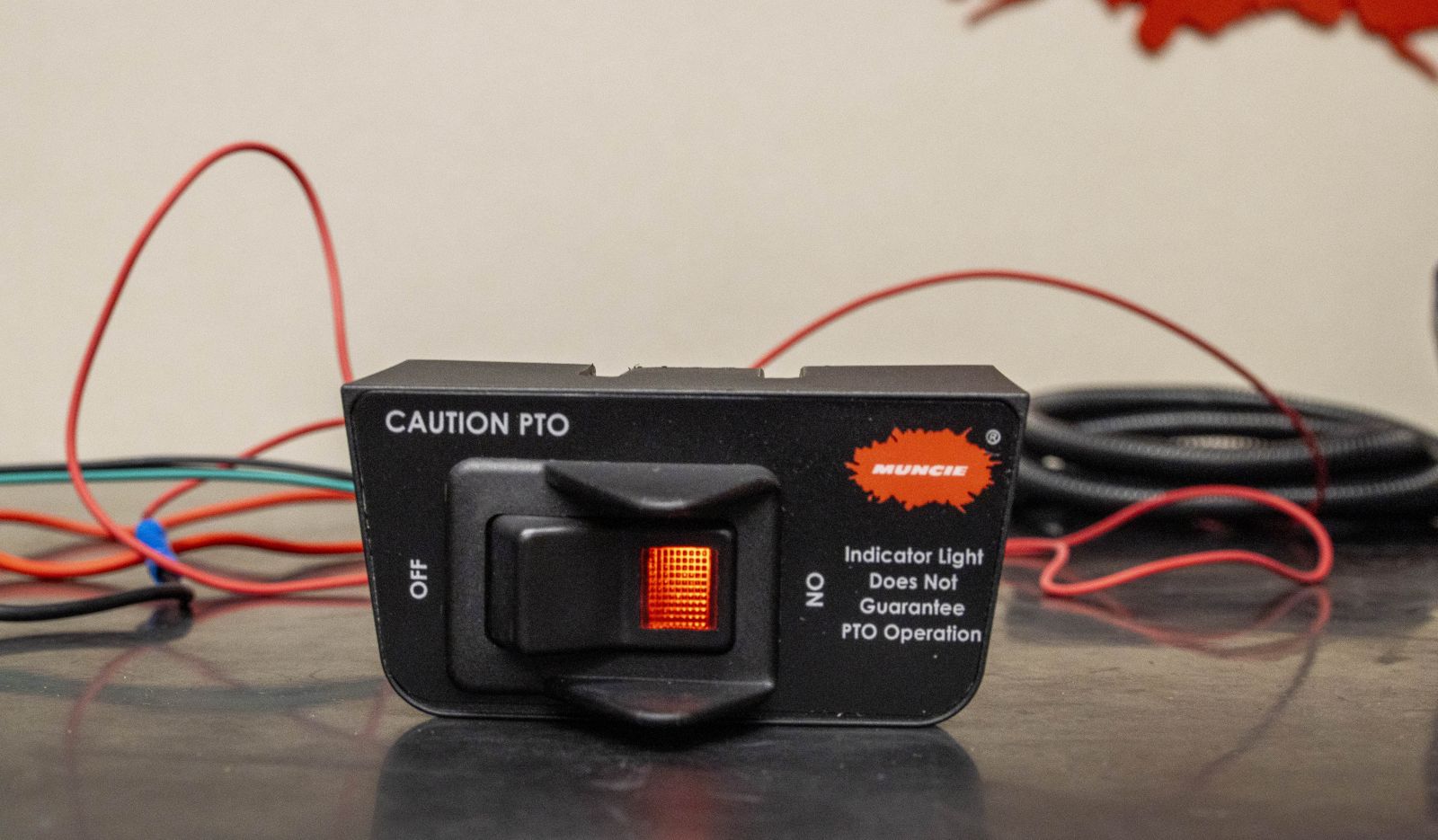 An image of a standard rocker switch provided by Muncie Power with a built-in indicator light.